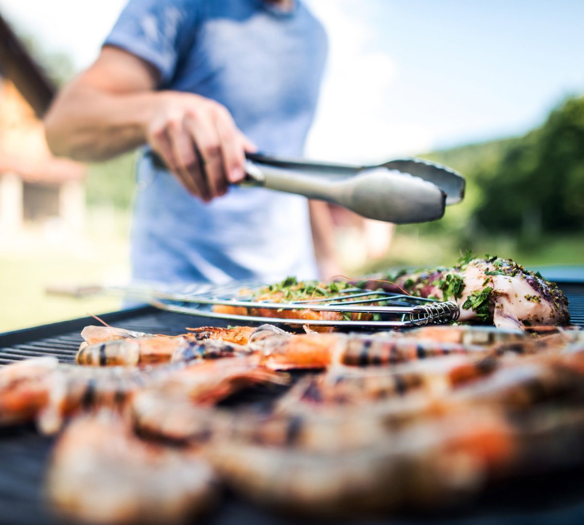 Prawns and chicken cooking on an outdoor barbecue